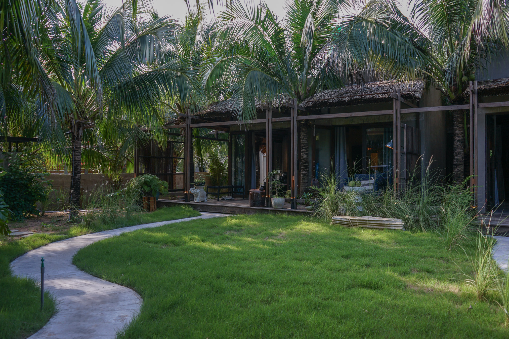 Ngôi nhà Mũi Né Hideaway nhìn từ sân cỏ và những hàng dừa
